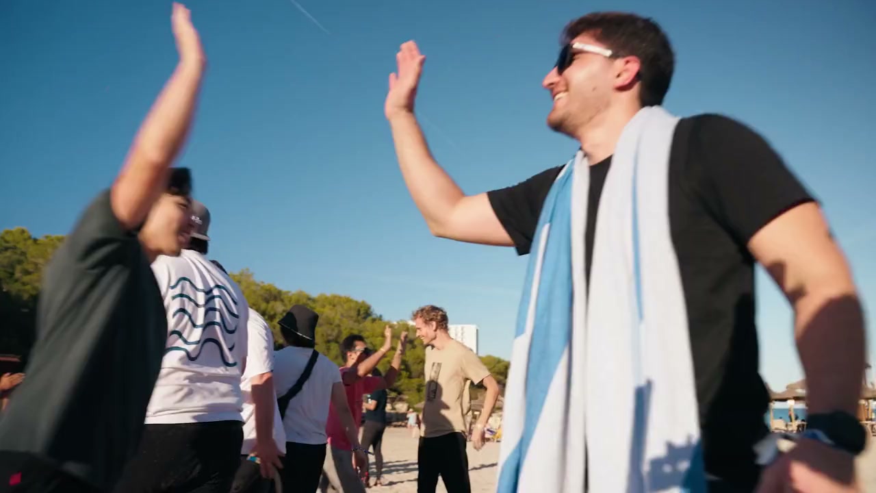 Trivago team members high-fiving during a beach activity in Mallorca