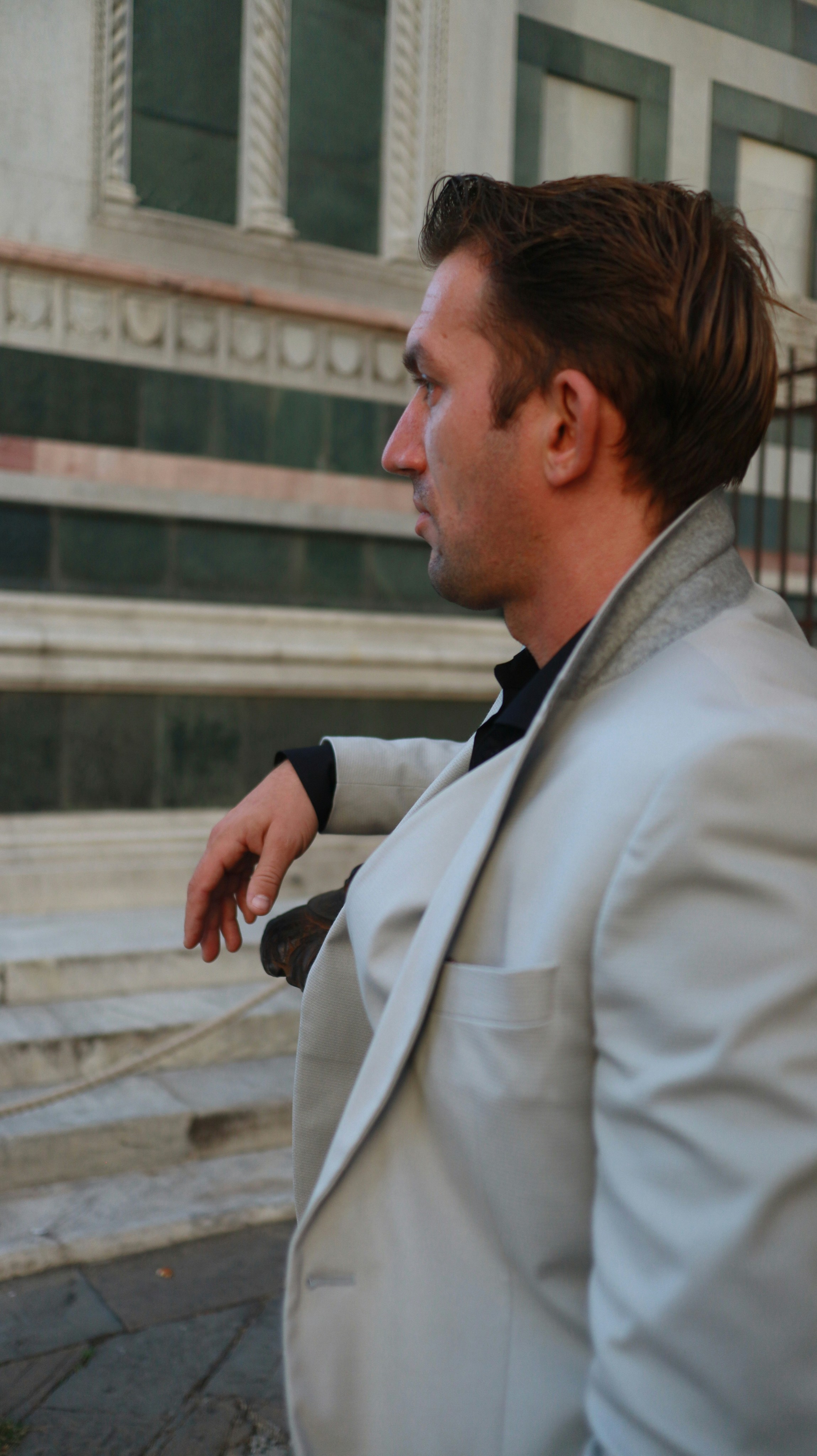a man in a white suit sitting on a bench