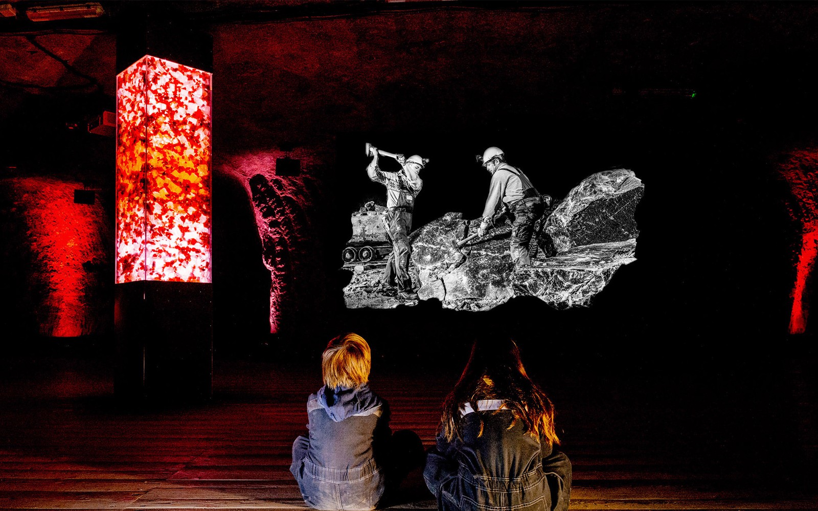 Børn ser på en udstilling om en saltmine i Salzburg med oplyste røde søjler.