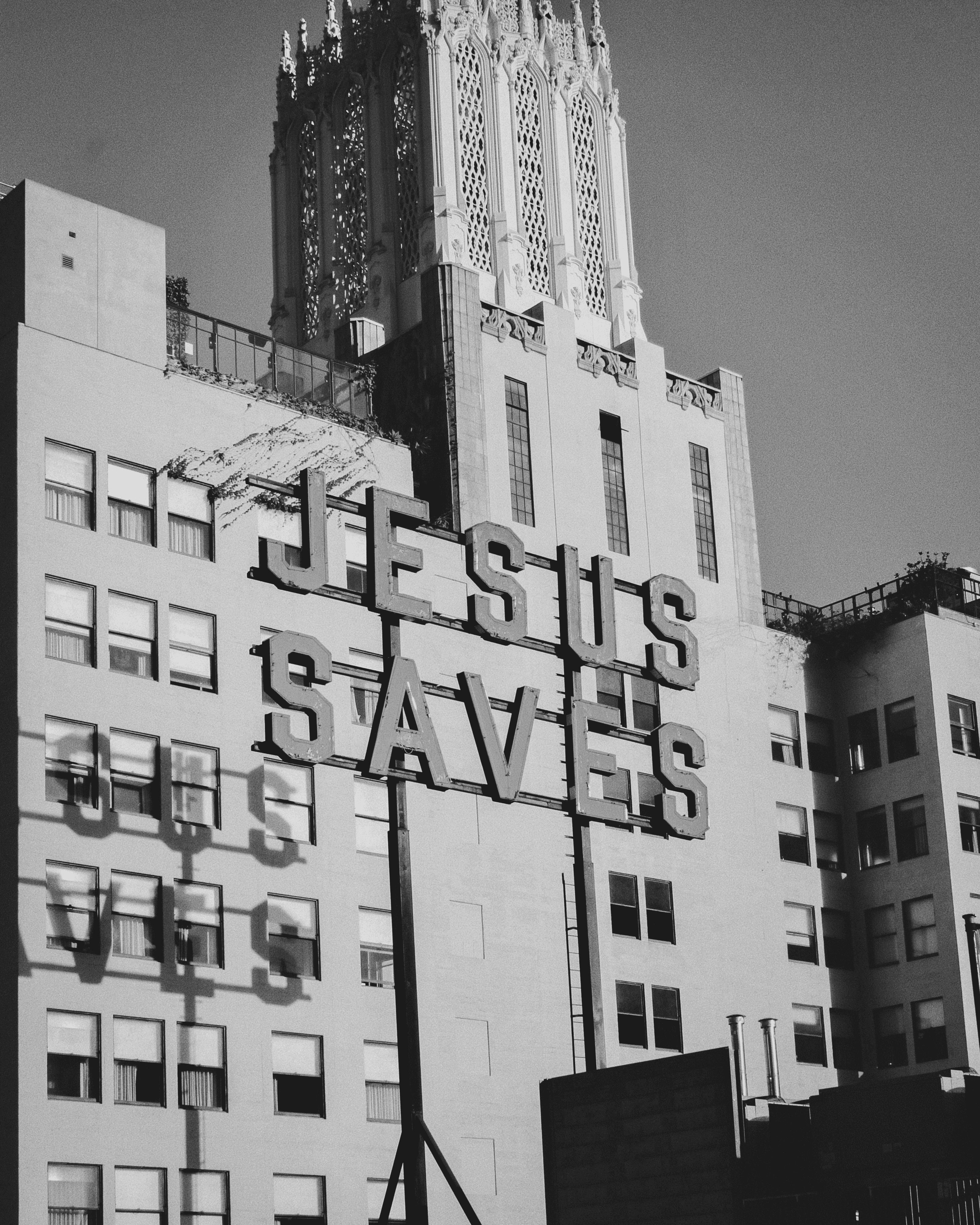 A man with glasses and a brown shirt, crossing his arms.