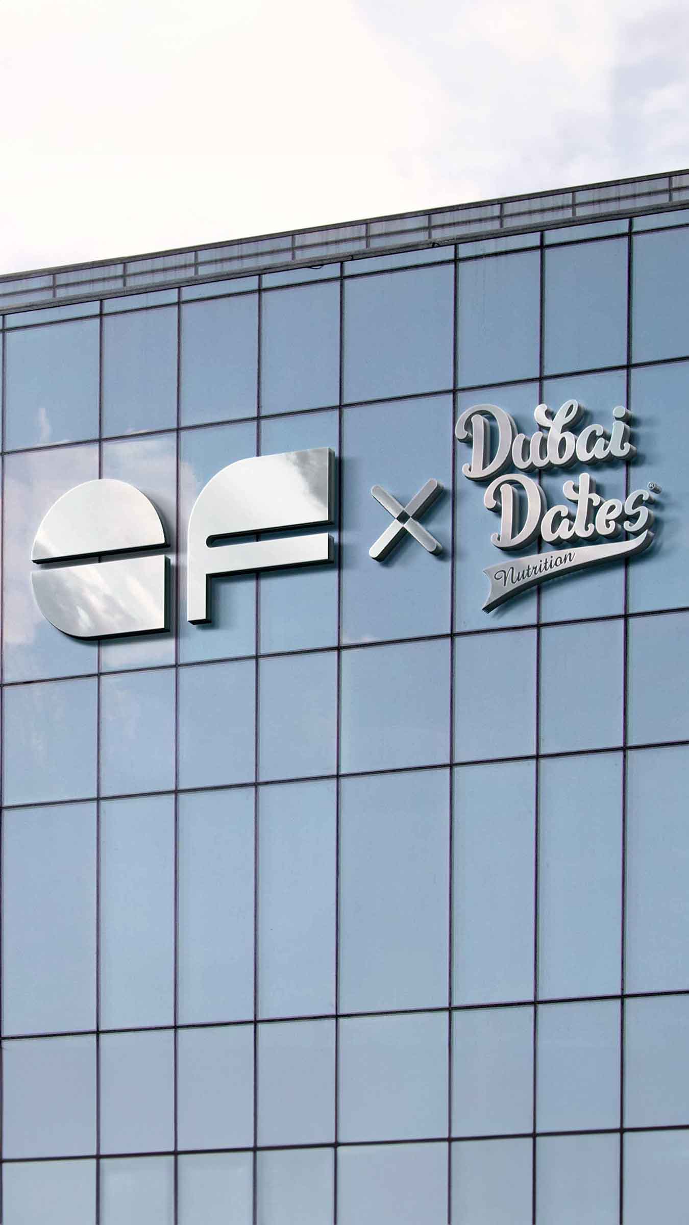 Glass building with Elite Fit and Dubai Dates Nutrition logo on a metal signage.