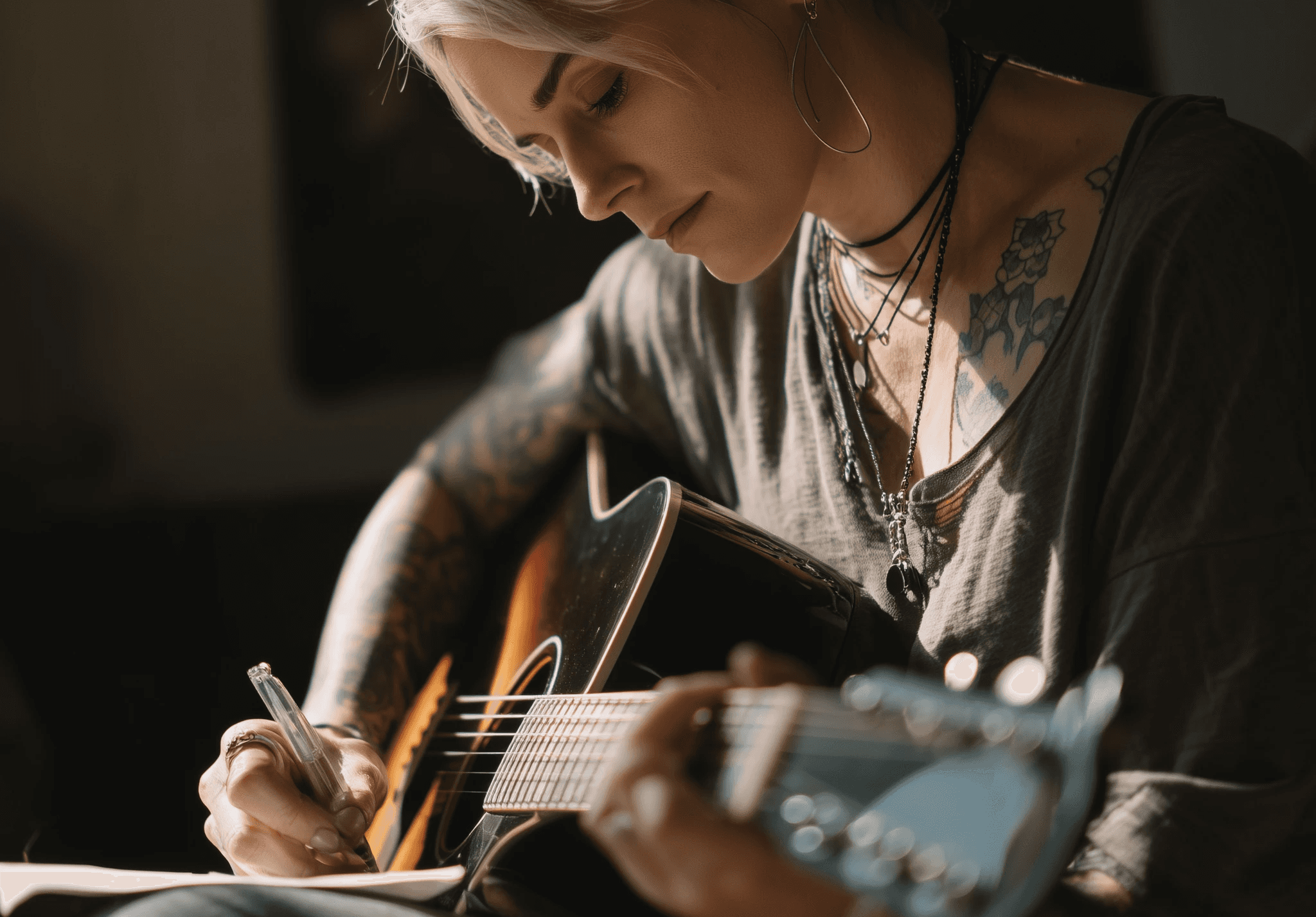 Woman songwriting with a guitar