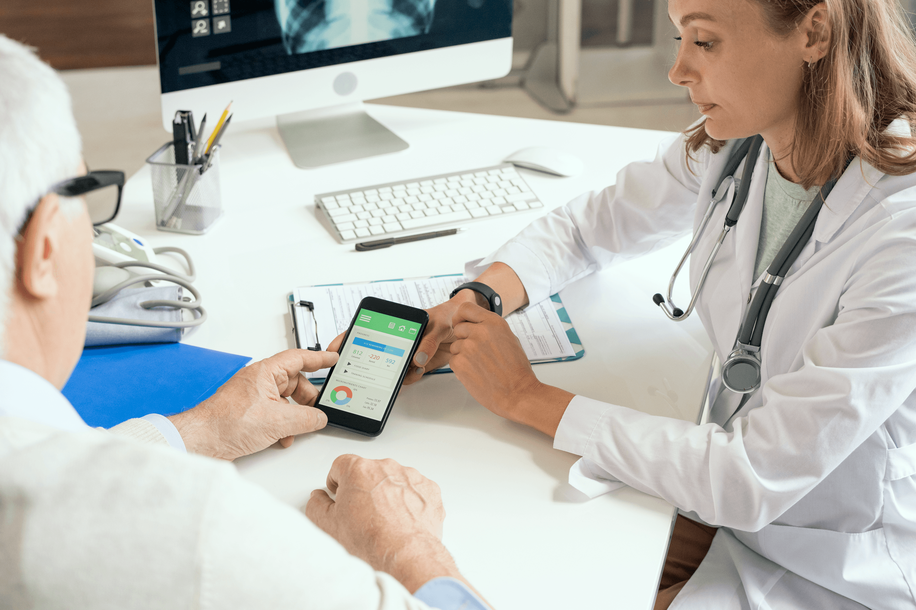 Alt text: Doctor reviewing a patient’s health data app on a smartphone, representing FHIR integration data flows, interoperability testing, and secure record exchange.