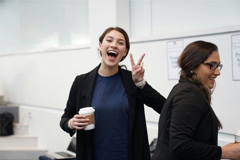 woman wearing suit making hand peace sign