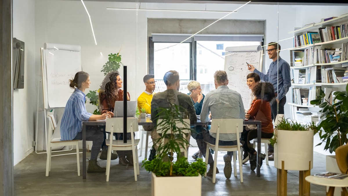 A group of people sitting in a room during an in-person facilitation training course