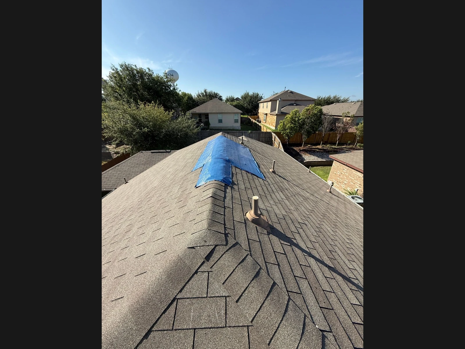 Temporary tarp over the damaged ridge before repair in Live Oak, Texas.