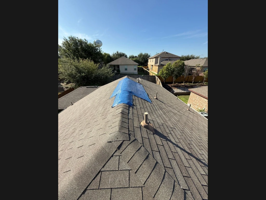 Temporary tarp over the damaged ridge before repair in Live Oak, Texas.