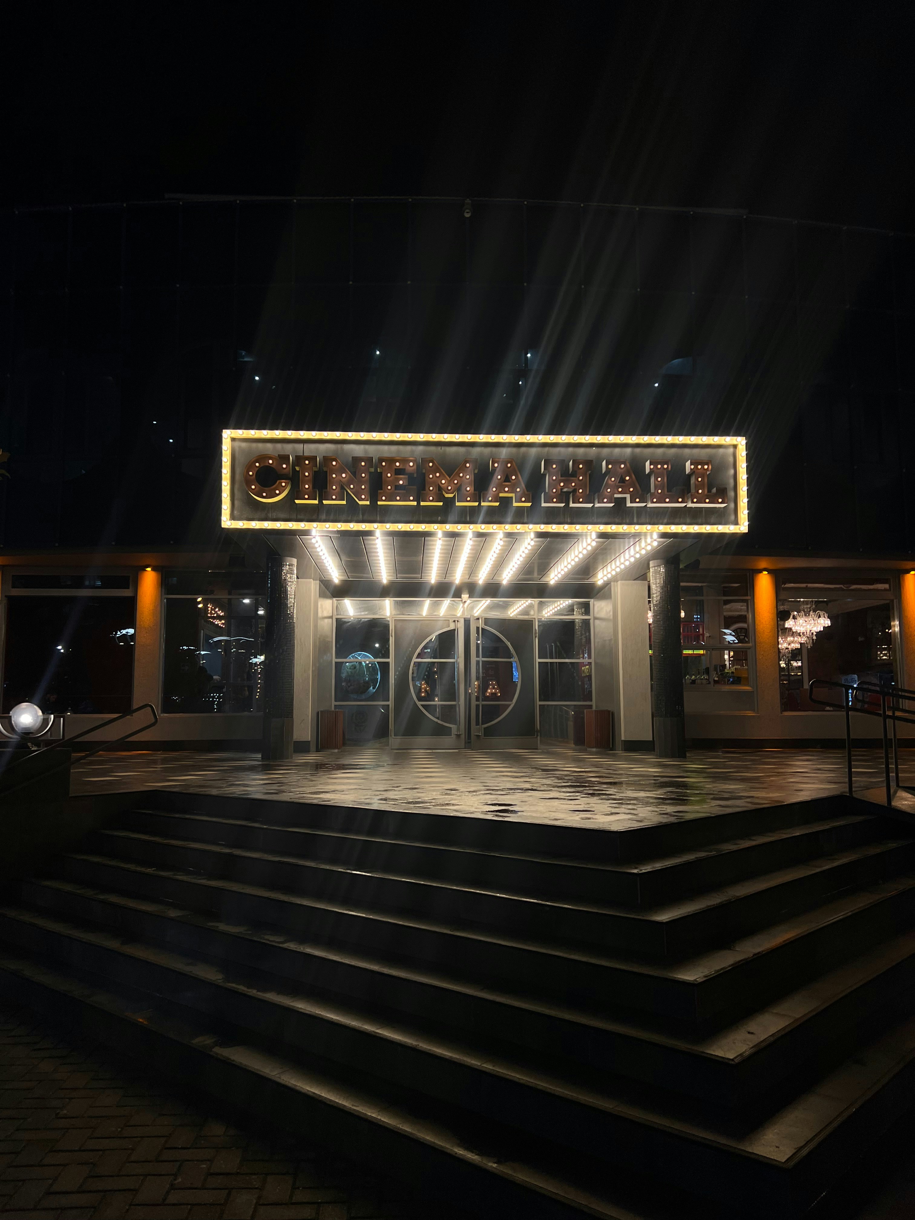 the entrance to a theater lit up at night