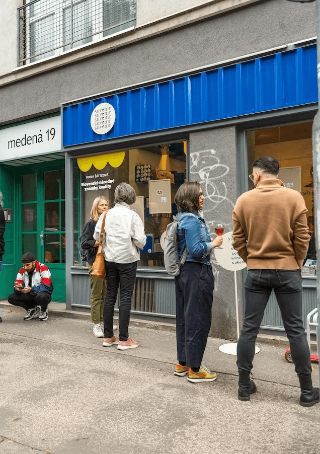 žltý smiley objekt visiaci v priestore pred človekom – výstava Niny A. Šoškovej