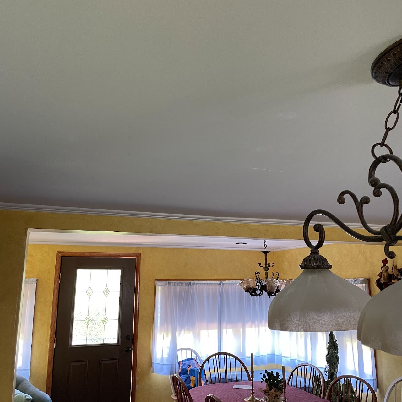 Smoothly repaired dining room ceiling with crown molding repainted