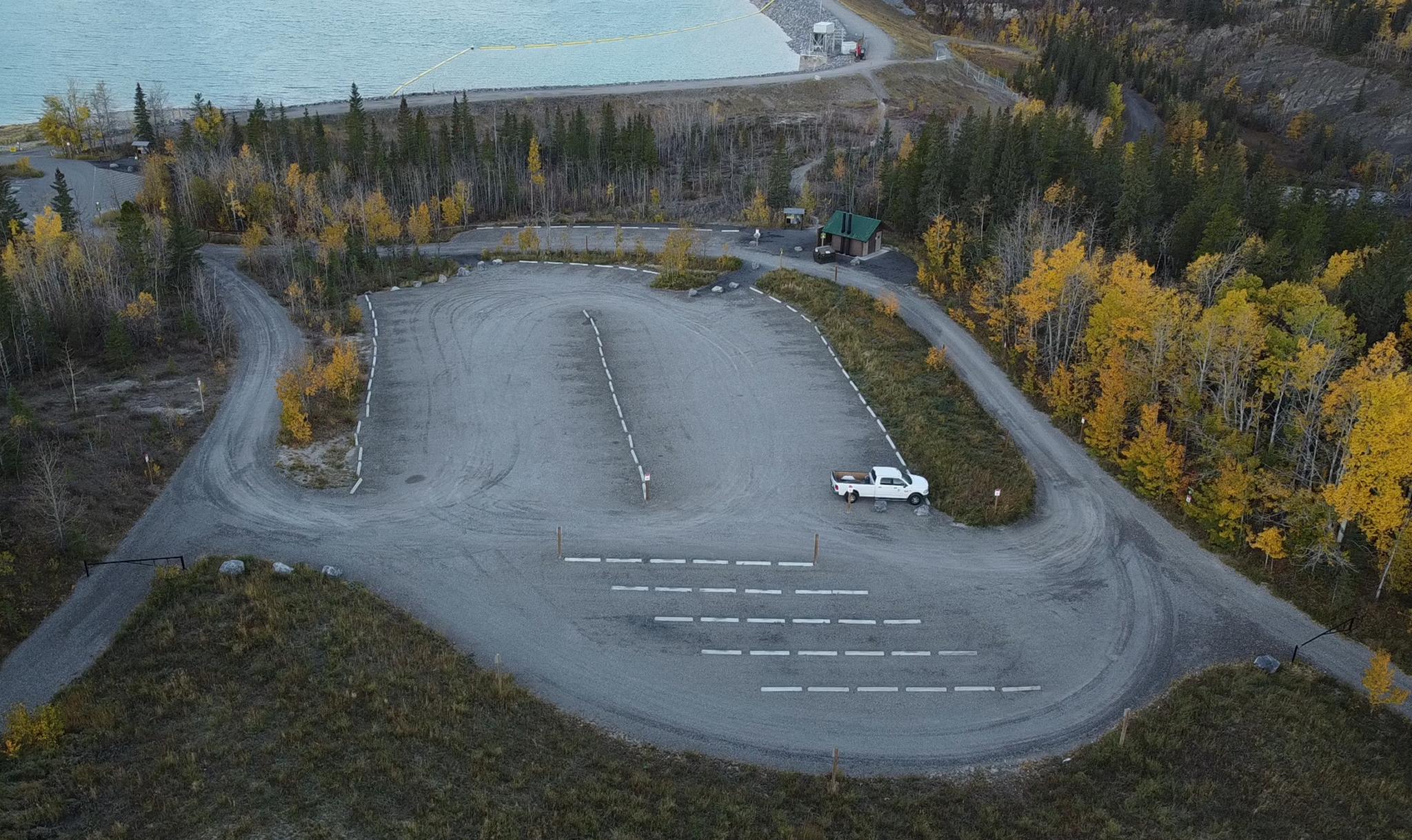 Aerial view of expanded Barrier Dam parking area with delineated spaces near Barrier Lake in Kananaskis