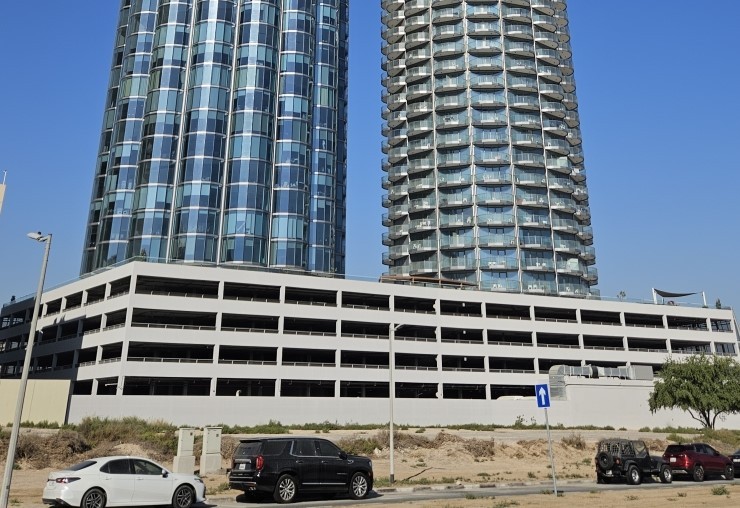 Modern exterior of Donna Towers featuring twin glass facades for luxury living and office spaces.