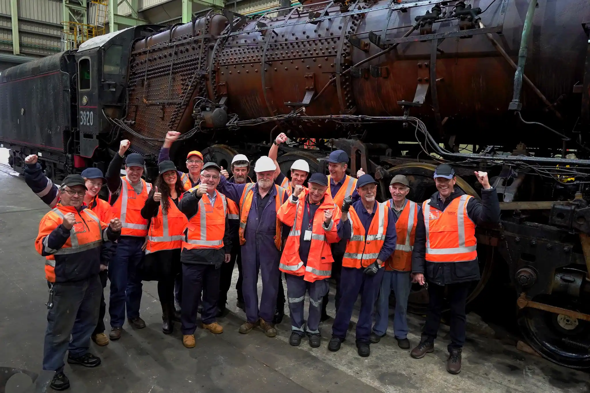 THNSW team members cheer in front of locomotive 3820 at Chullora