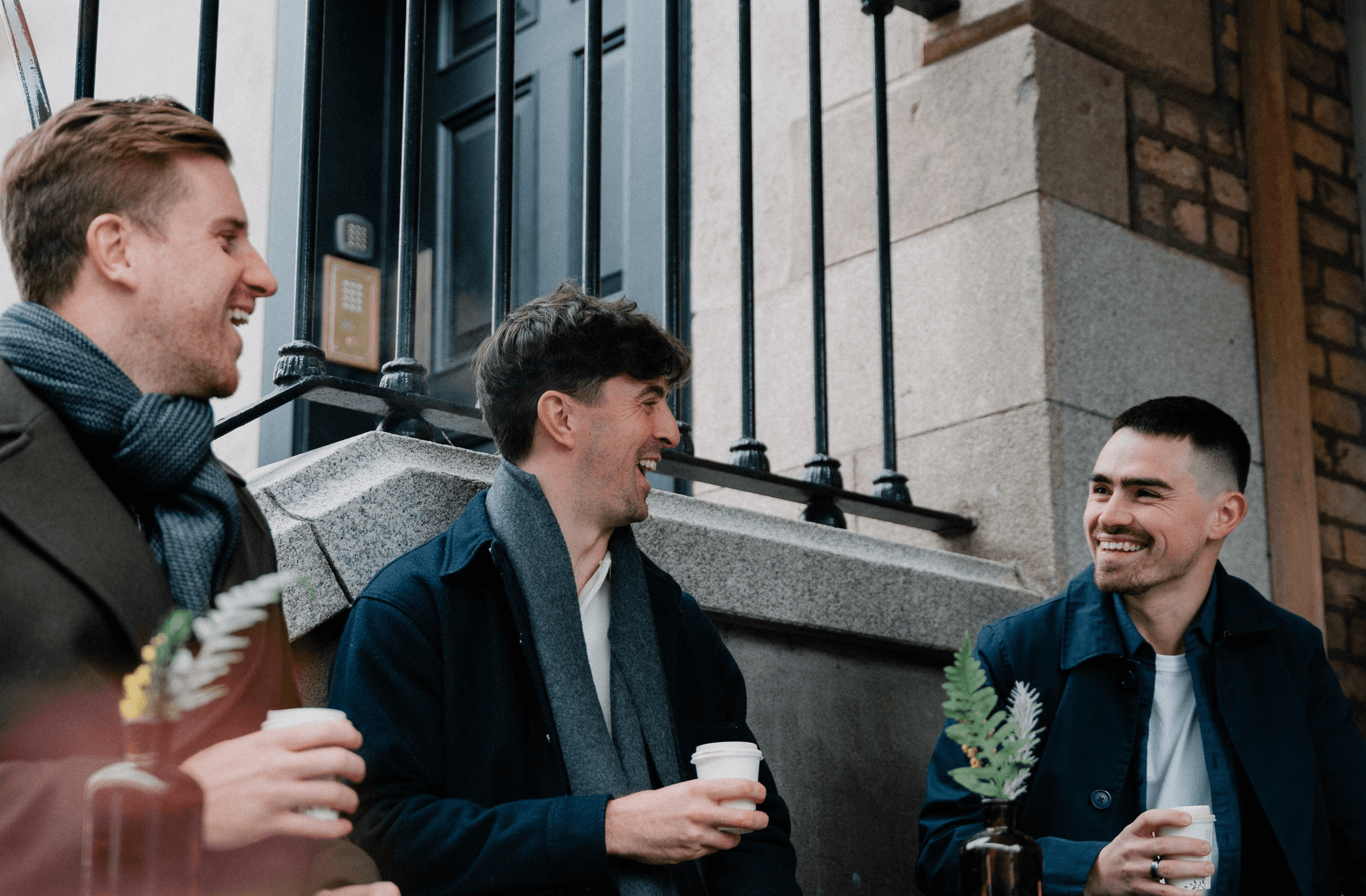 Three professionals smiling while walking outside office building – CSM consultation call-to-action banner.