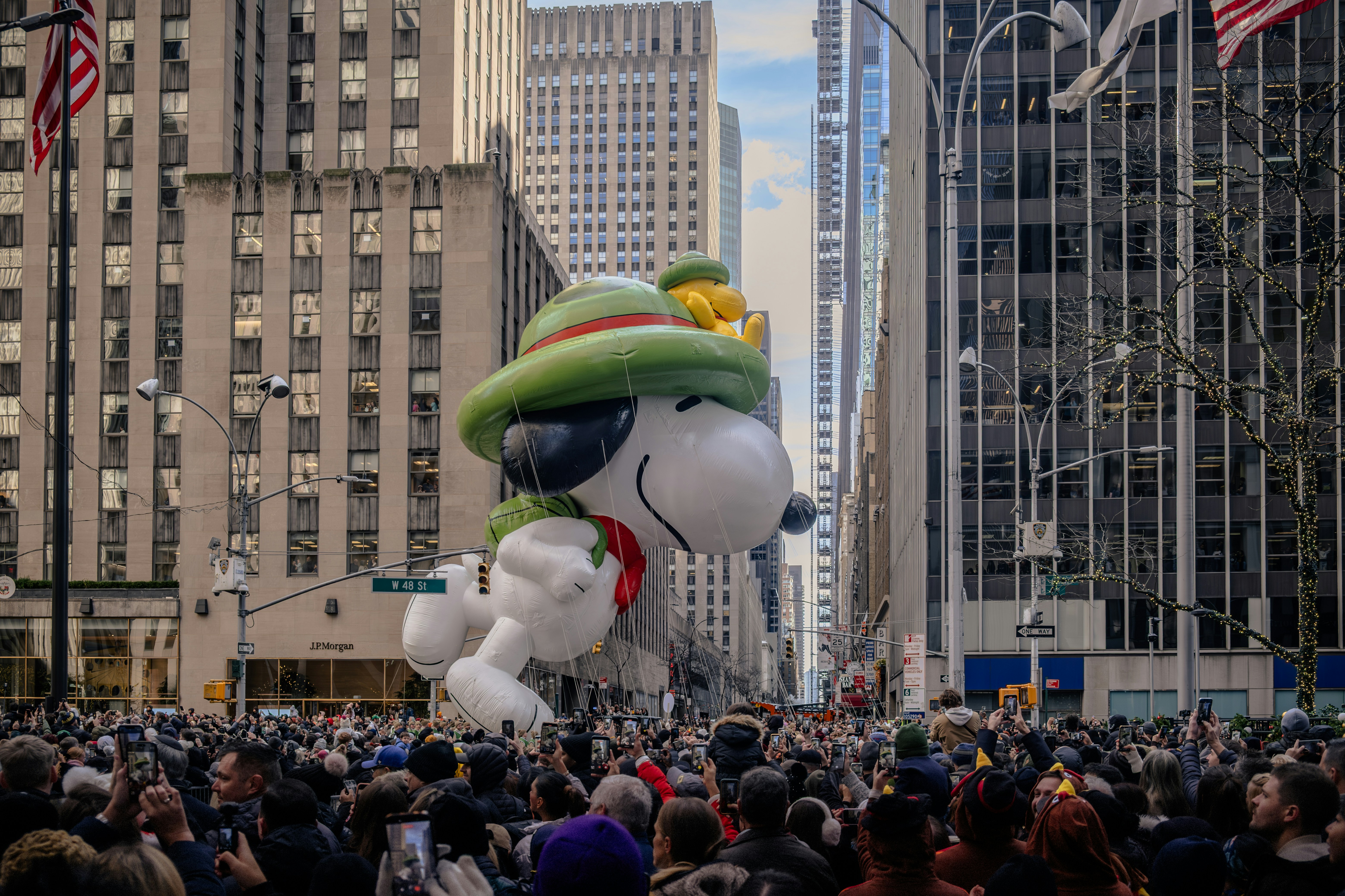 Snoopy balloon floats down a city street parade.