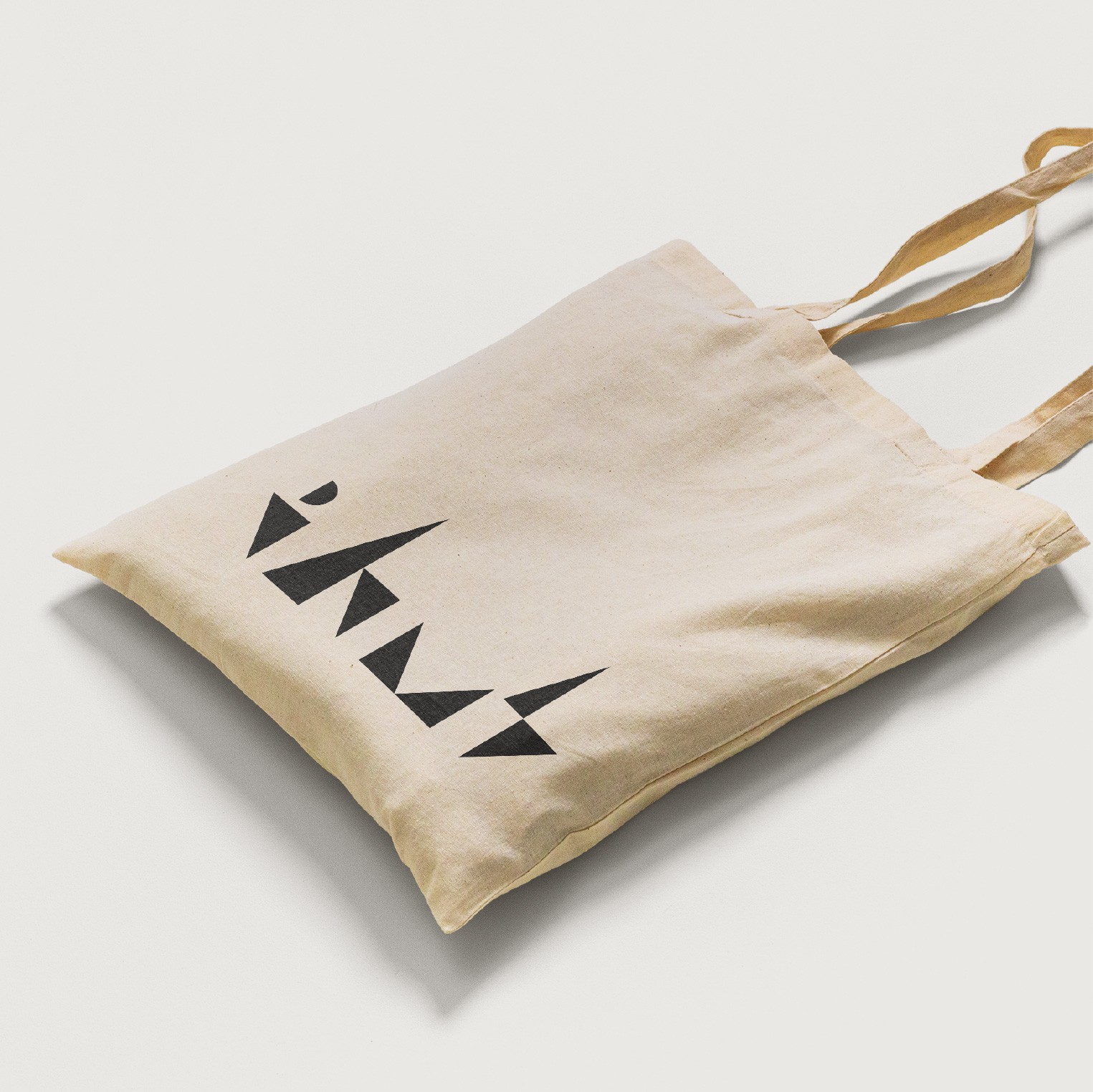 White tote bag with black logo for IHMS