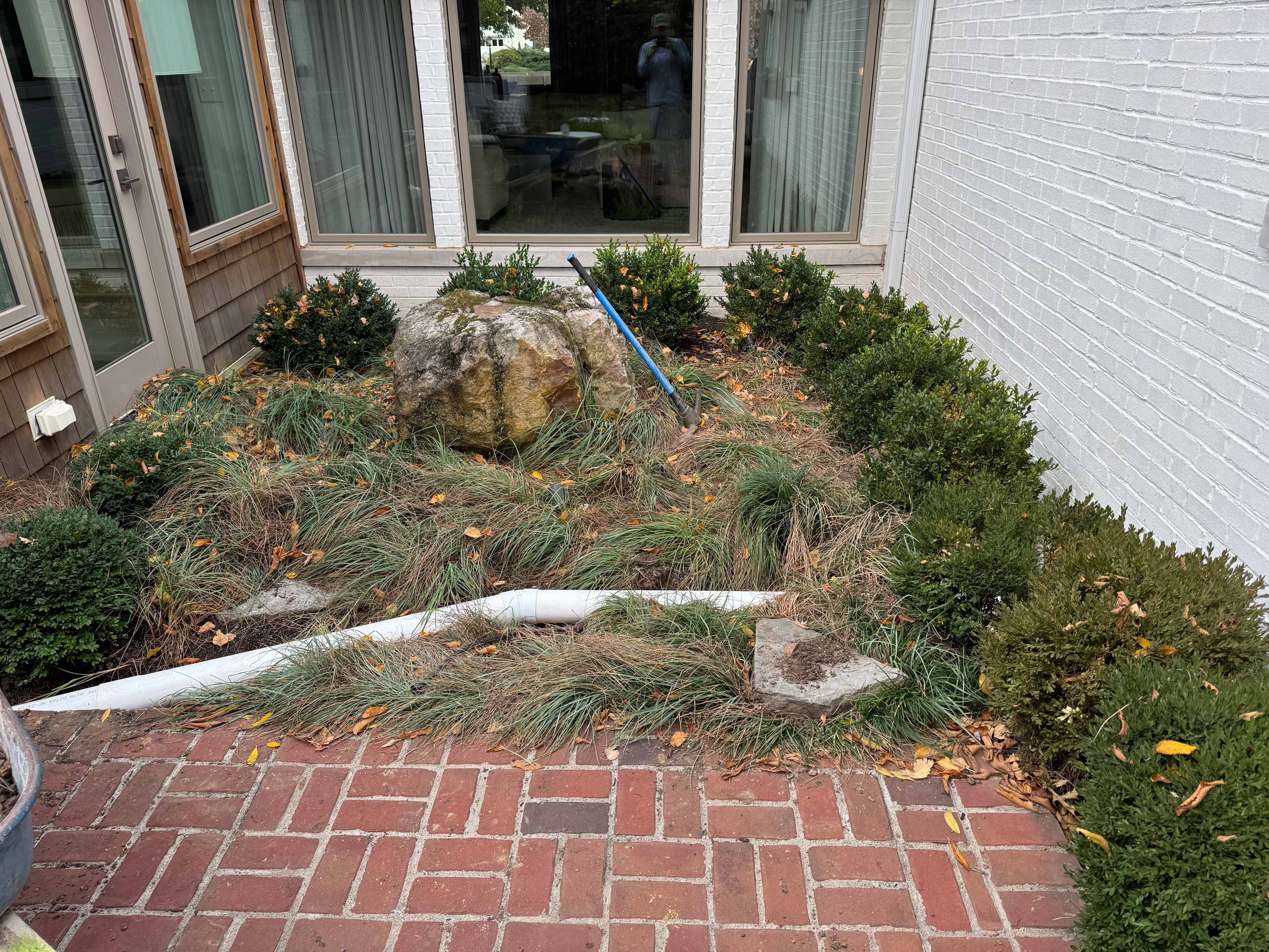 Drain pipe installation in progress around garden bed