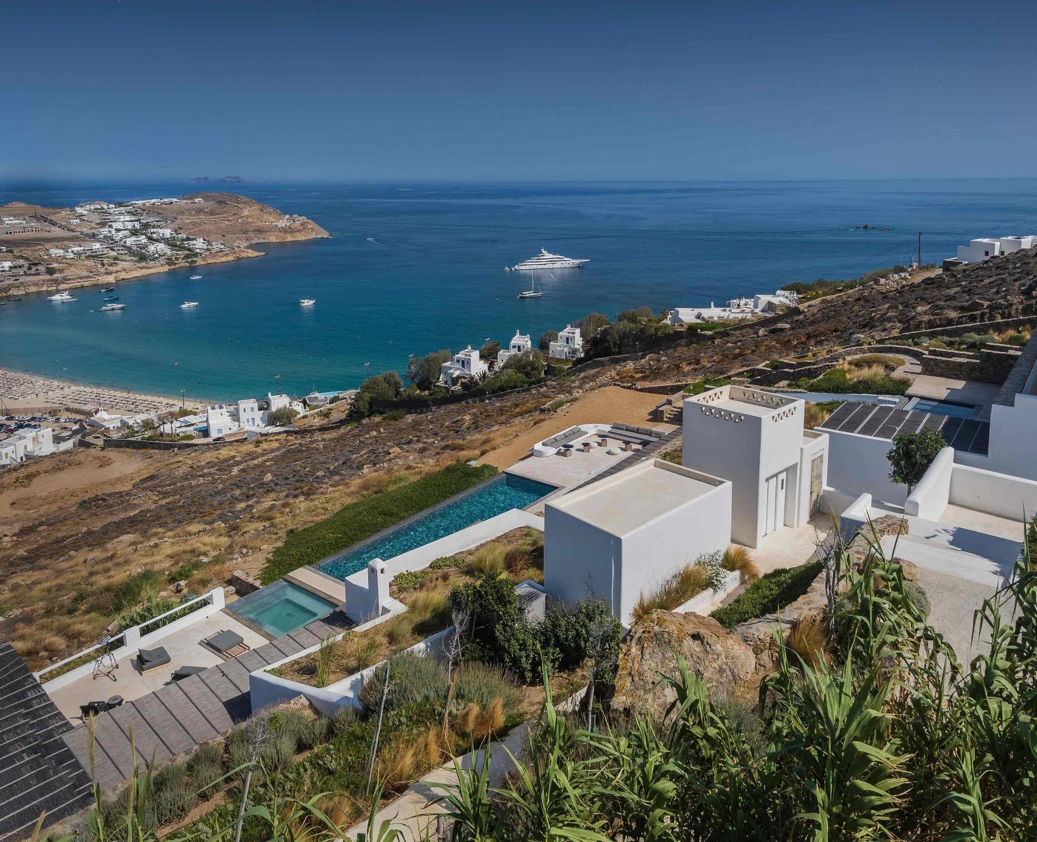 a large white building sitting on top of a lush green hillside