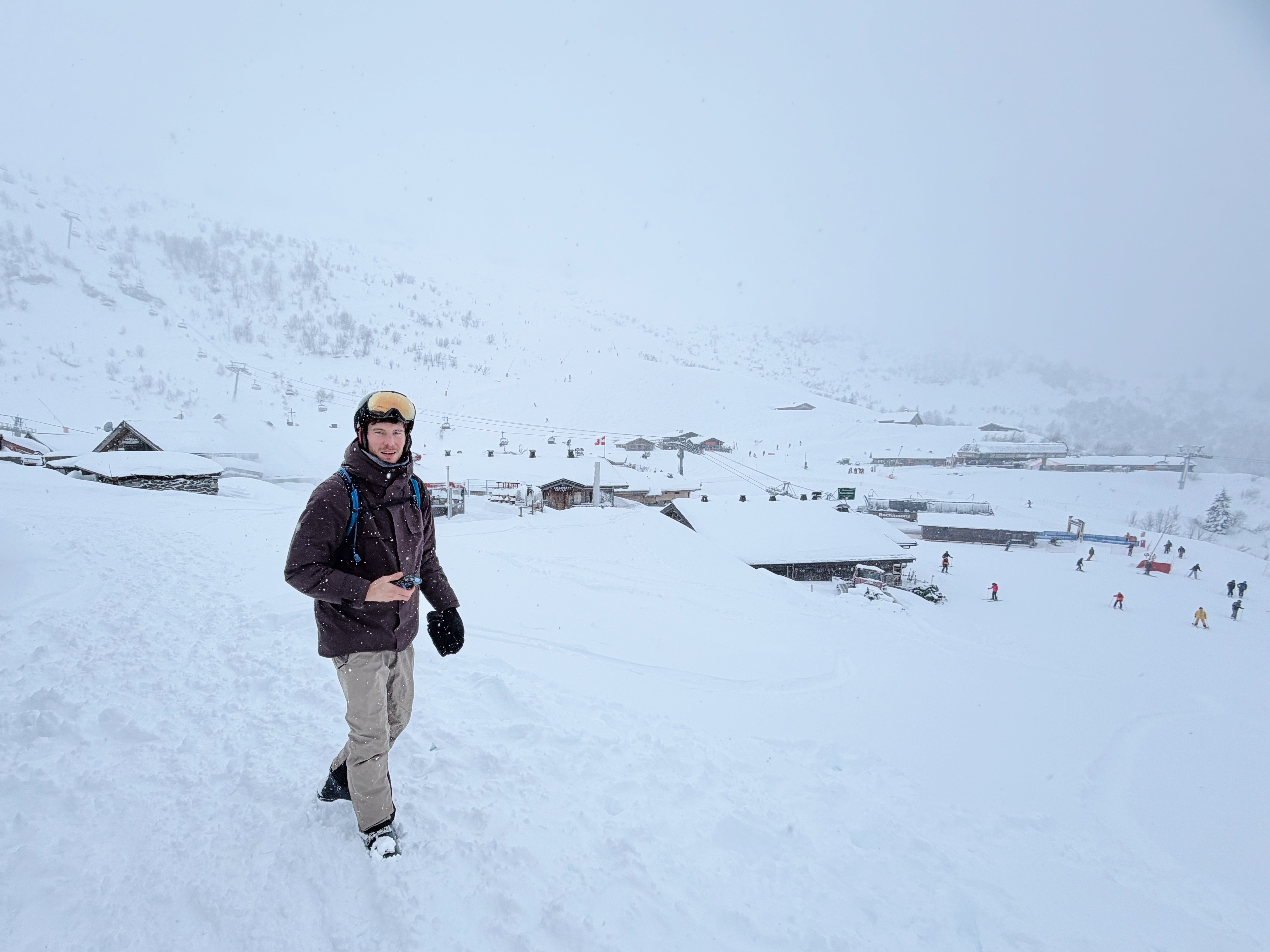 Matt walks through the snow with the Plaine Dranse mountain hub in the background.