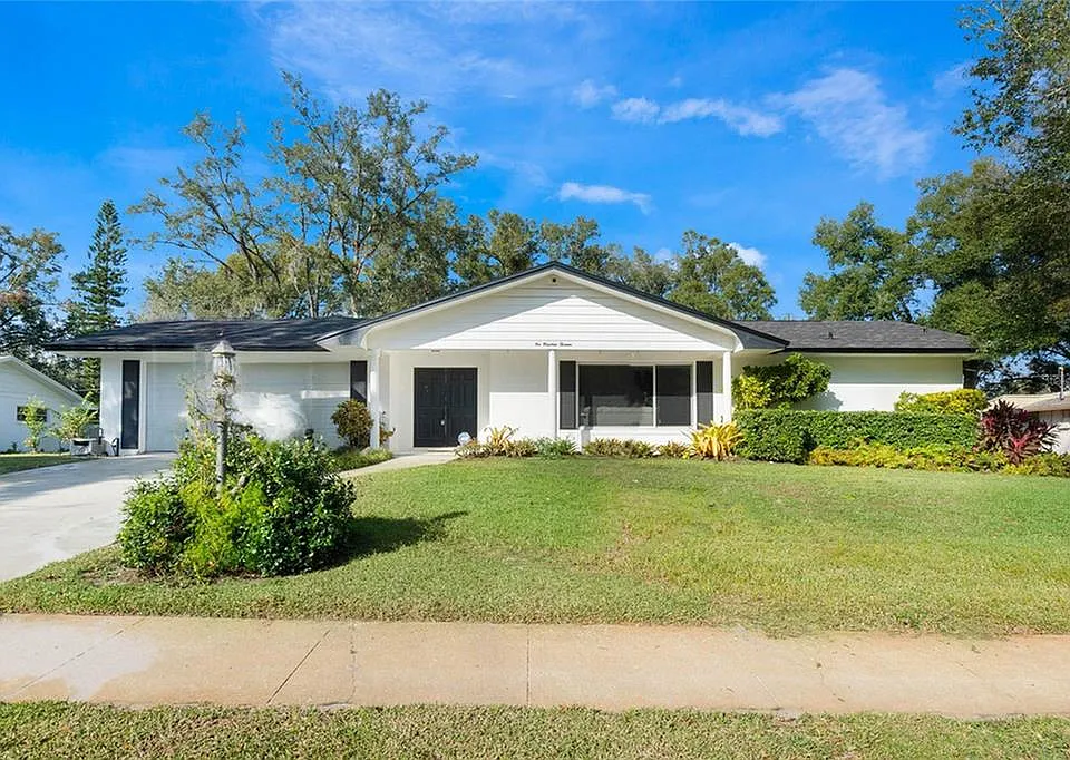 brown and white concrete house near green grass field during daytime