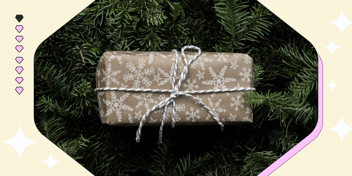 Beautifully wrapped Christmas gift sitting on pine branches, symbolizing thoughtful holiday gifts for nurses.