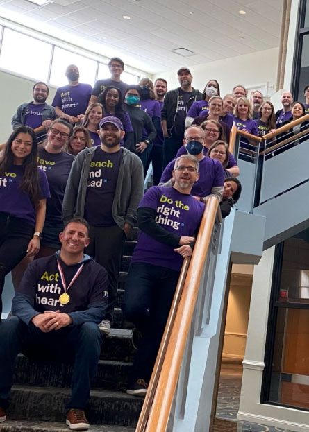 Group photo of the BrandExtract team on a set of stairs with JC in the center