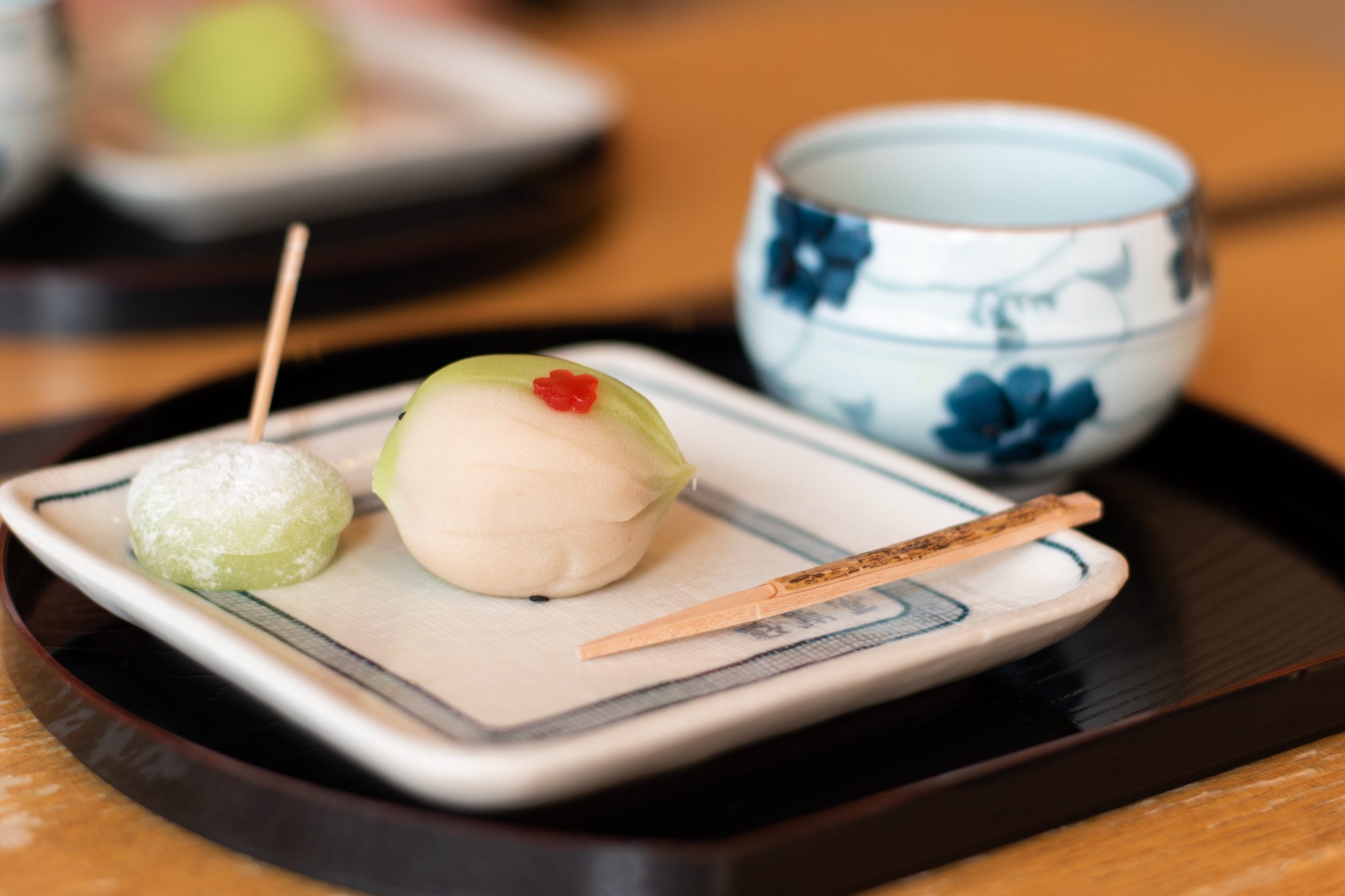 Japanese seasonal wagashi served on a small tray with a tiny cup of tea