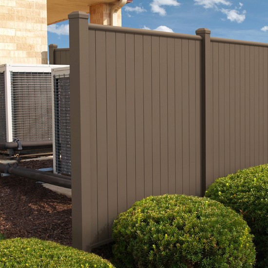 A close-up of a brown aluminum privacy screen acting as a cover-up for an outdoor home air conditioning unit.