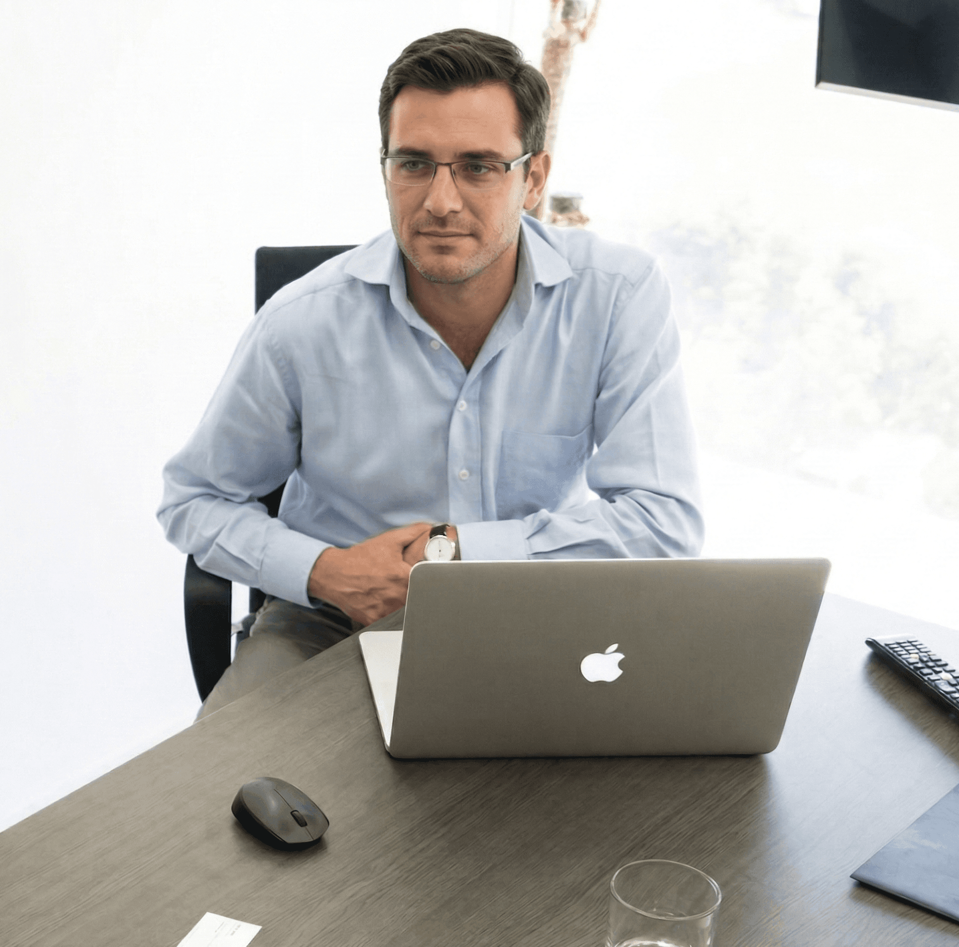 A desk with a laptop and an employee badge laying on top of it.