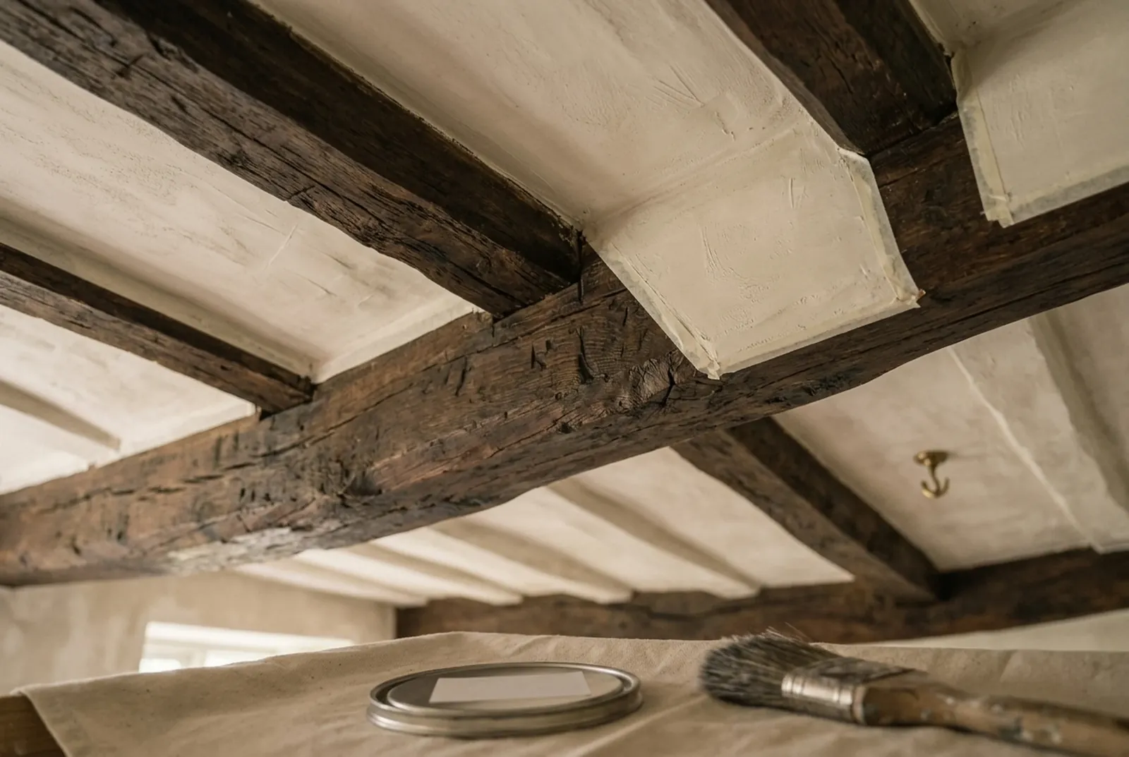 Dark oak ceiling beams between old-white limewashed plaster
