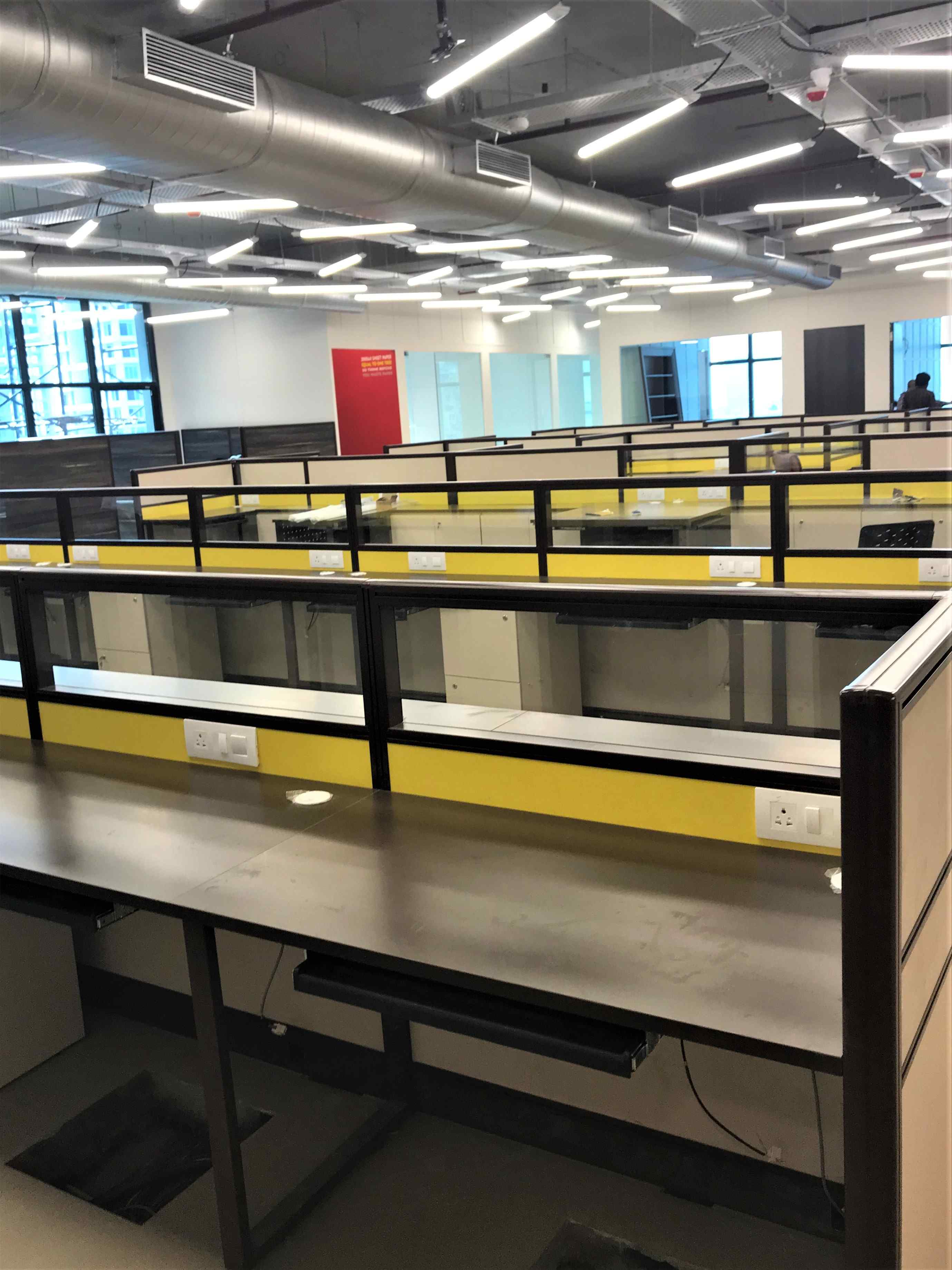Nature-inspired preschool entrance with sculptural tree partitions and suspended green leaf ceiling panels.
