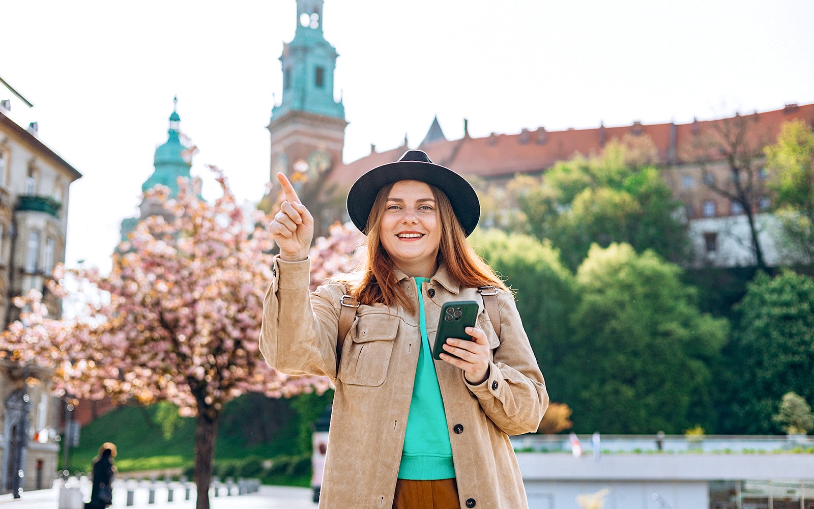 Tourist enjoying Wawel Castle view in Krakow during guided tour.