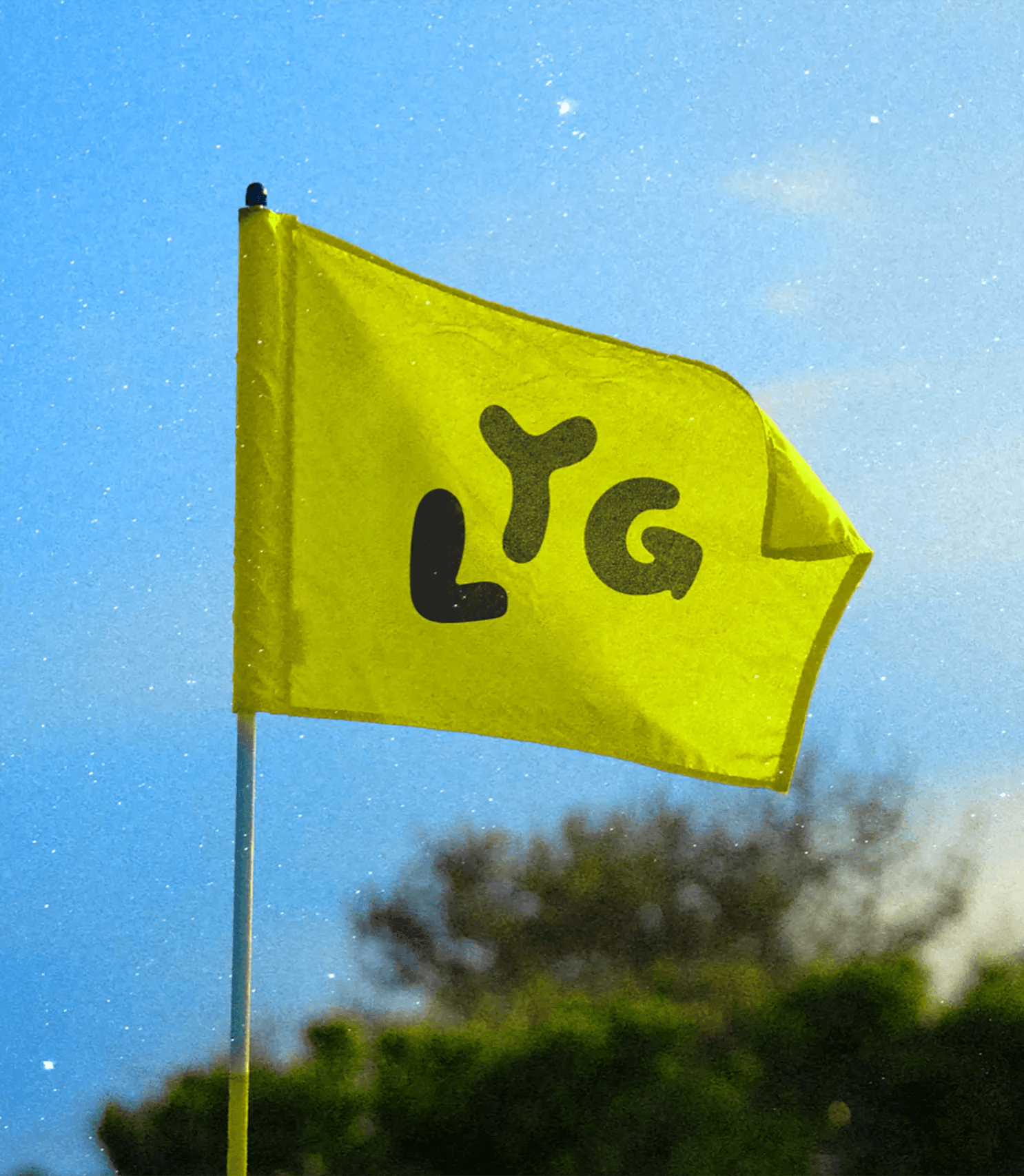 Bright yellow Liteyear Golf flag with LYG logo on a golf course