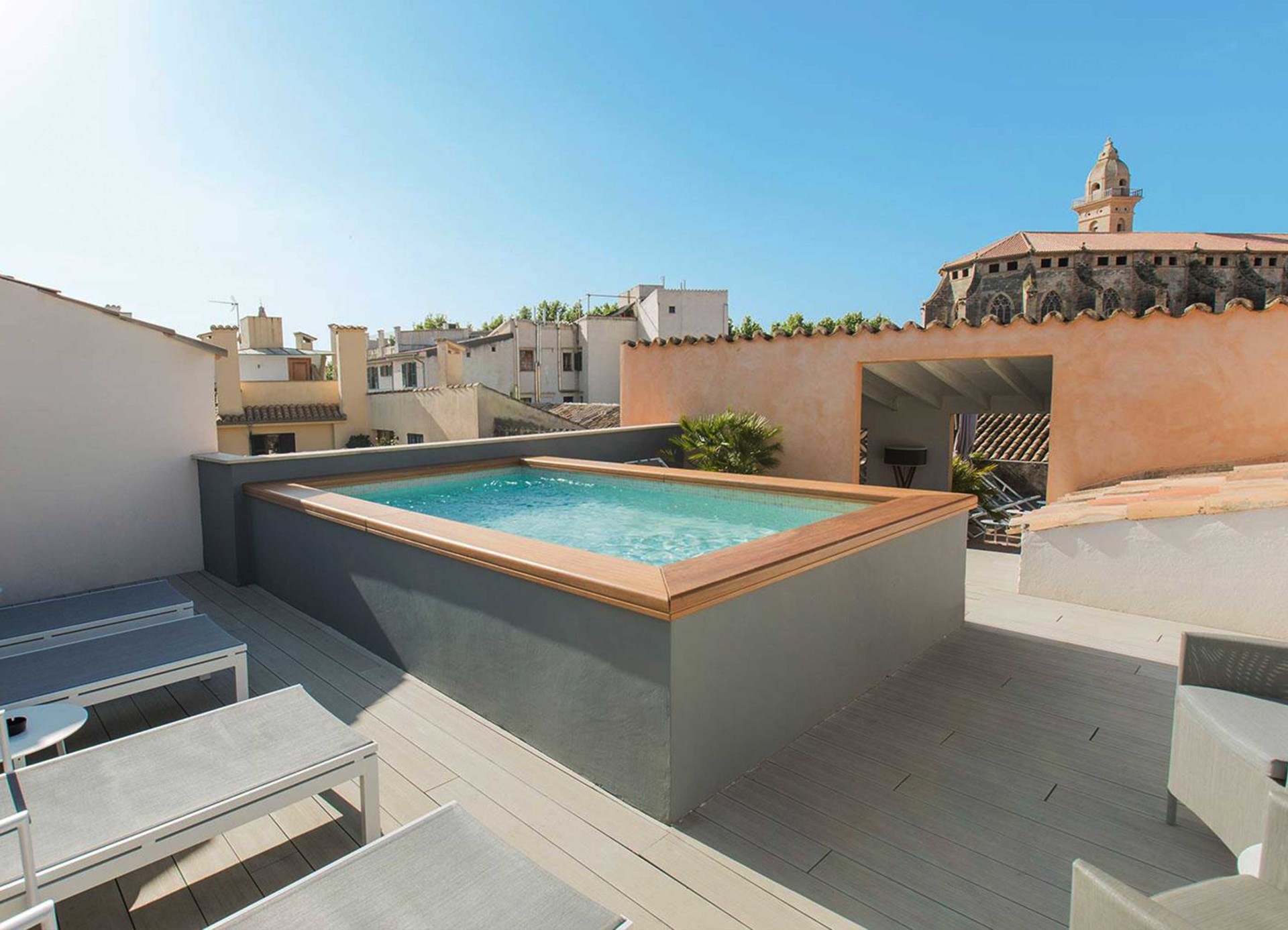 Piscina en terraza de Posada Tierra Santa con vistas a la ciudad y día soleado
