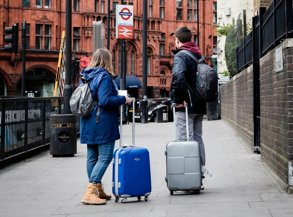 Personas con maletas en la ciudad, asociadas al ahorro para viajar