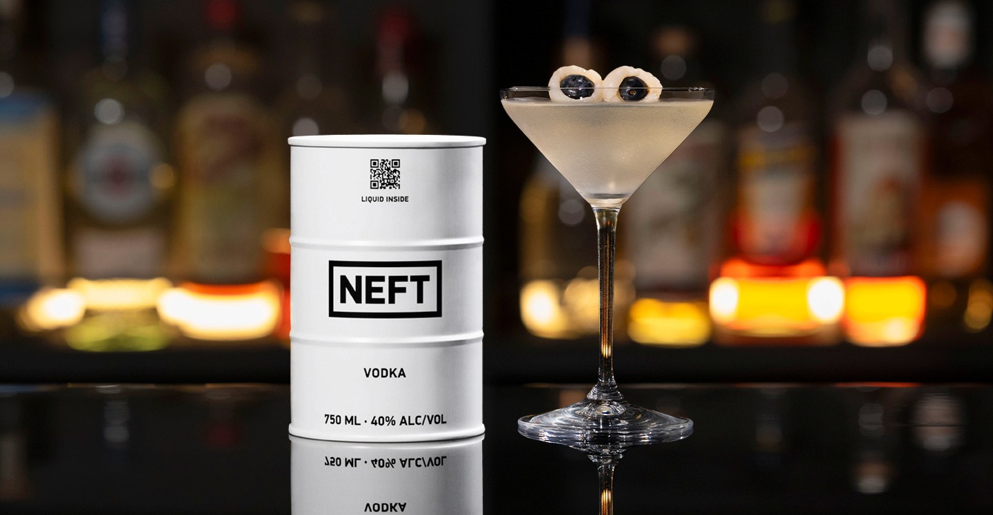 A NEFT Barrel and a glass of Saketini on a bar counter.