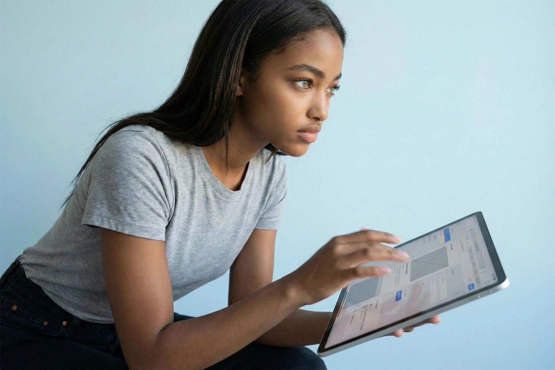 Symbolbild für Shopify-Shops: Eine Frau arbeitet konzentriert an einem Tablet und steht für skalierbare Shopify-Systeme, sauberes Setup und automatisierten Verkauf.