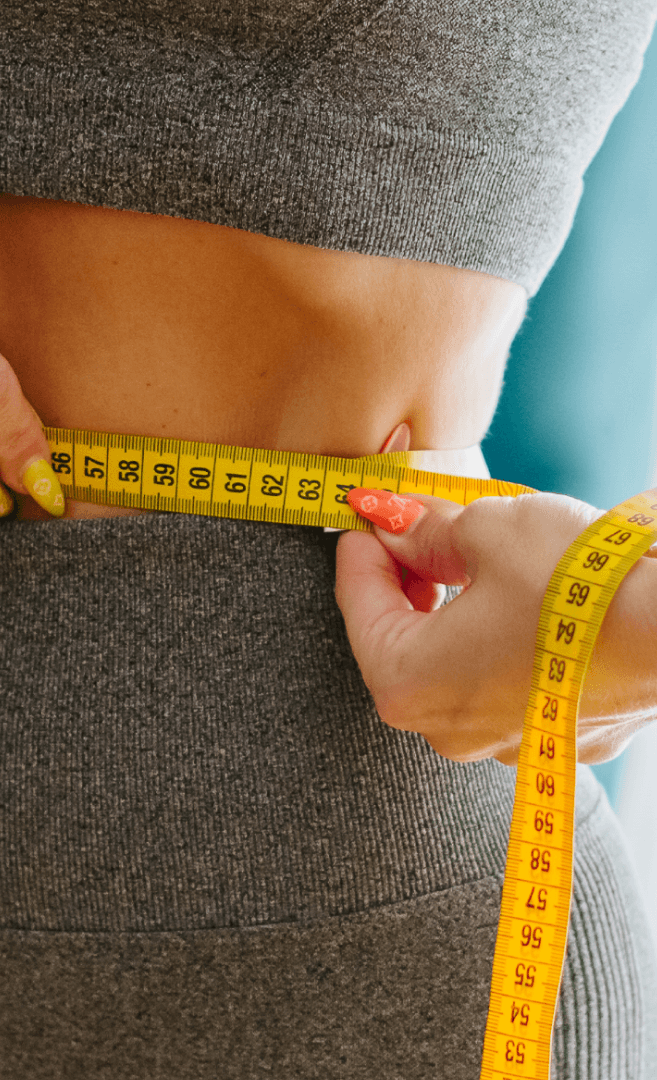 Close-up of a dark green leaf showing its textured surface and central vein against a muted background.