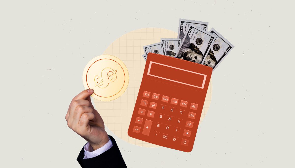 Hand holding coin beside calculator and cash, symbolizing annual income and how to calculate it from any pay period.