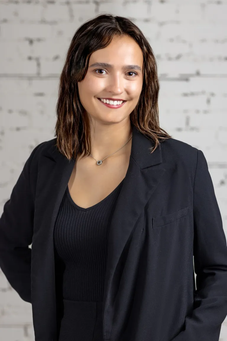 Image of Woman in black blazer smiling at KHD Homes design and construction services presentation.