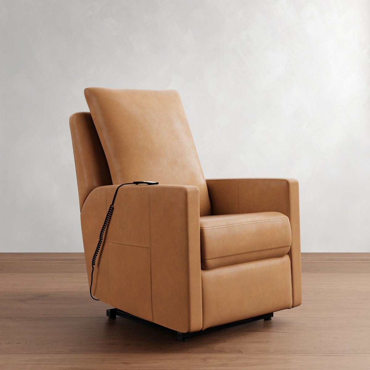 Tan leather Pottery Barn Ayden power lift recliner with a minimalist look on a wooden floor