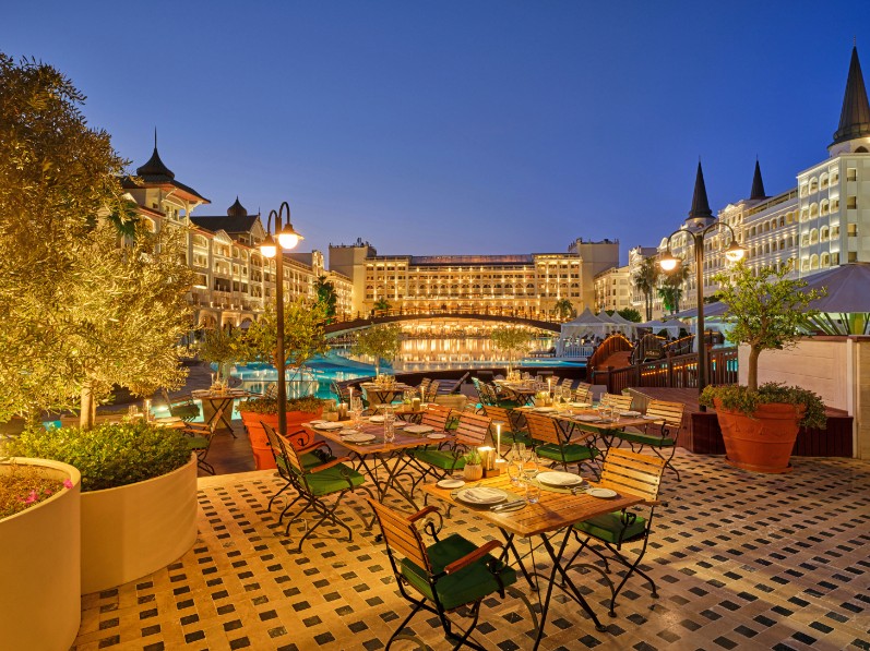 A light-filled fitness space with arched windows inside a coastal Mediterranean-modern villa, facing the ocean. 