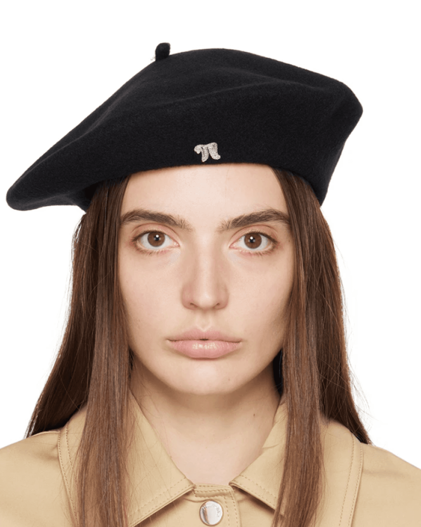 Femme portant un béret noir avec un petit emblème, habillée en veste beige