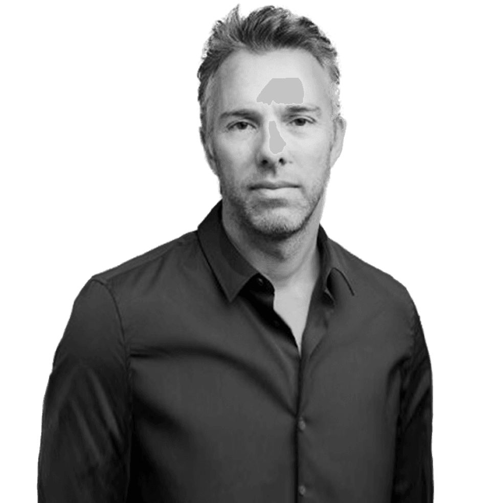 Black and white photo of European white man looking into camera, back button-up shirt