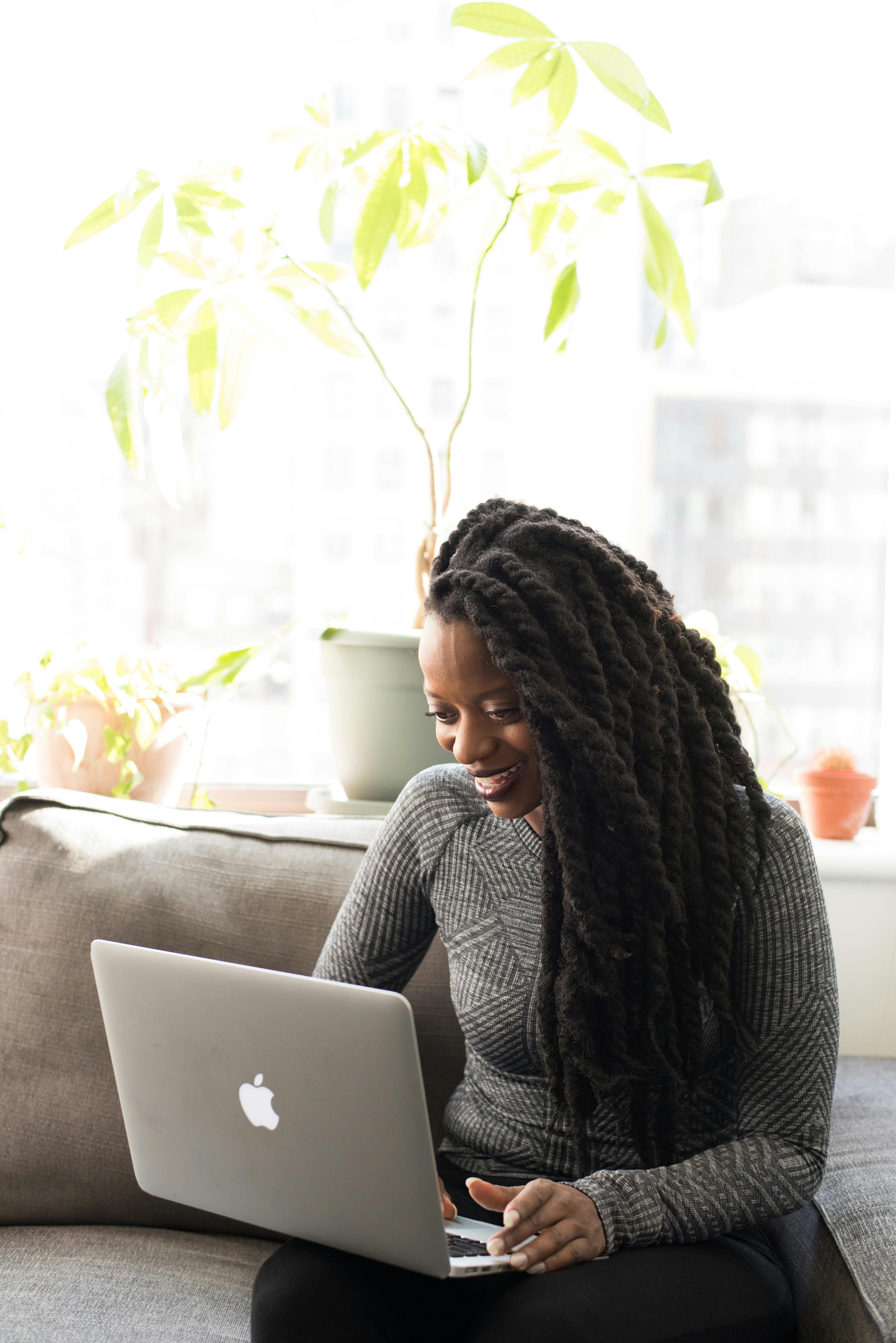 Young woman smiling looking at her laptop screen