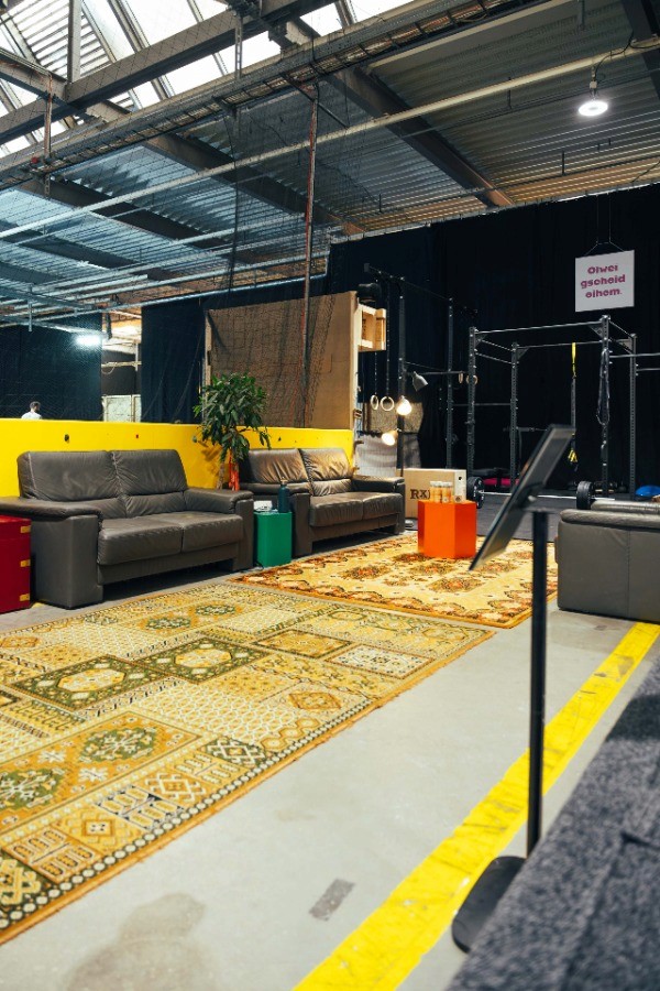 Urbaner Indoor-Boulderraum mit Lounge-Bereich und digital gesteuerter Shiny Wall Systemwand – Bouldern, Community und Functional Fitness in München.