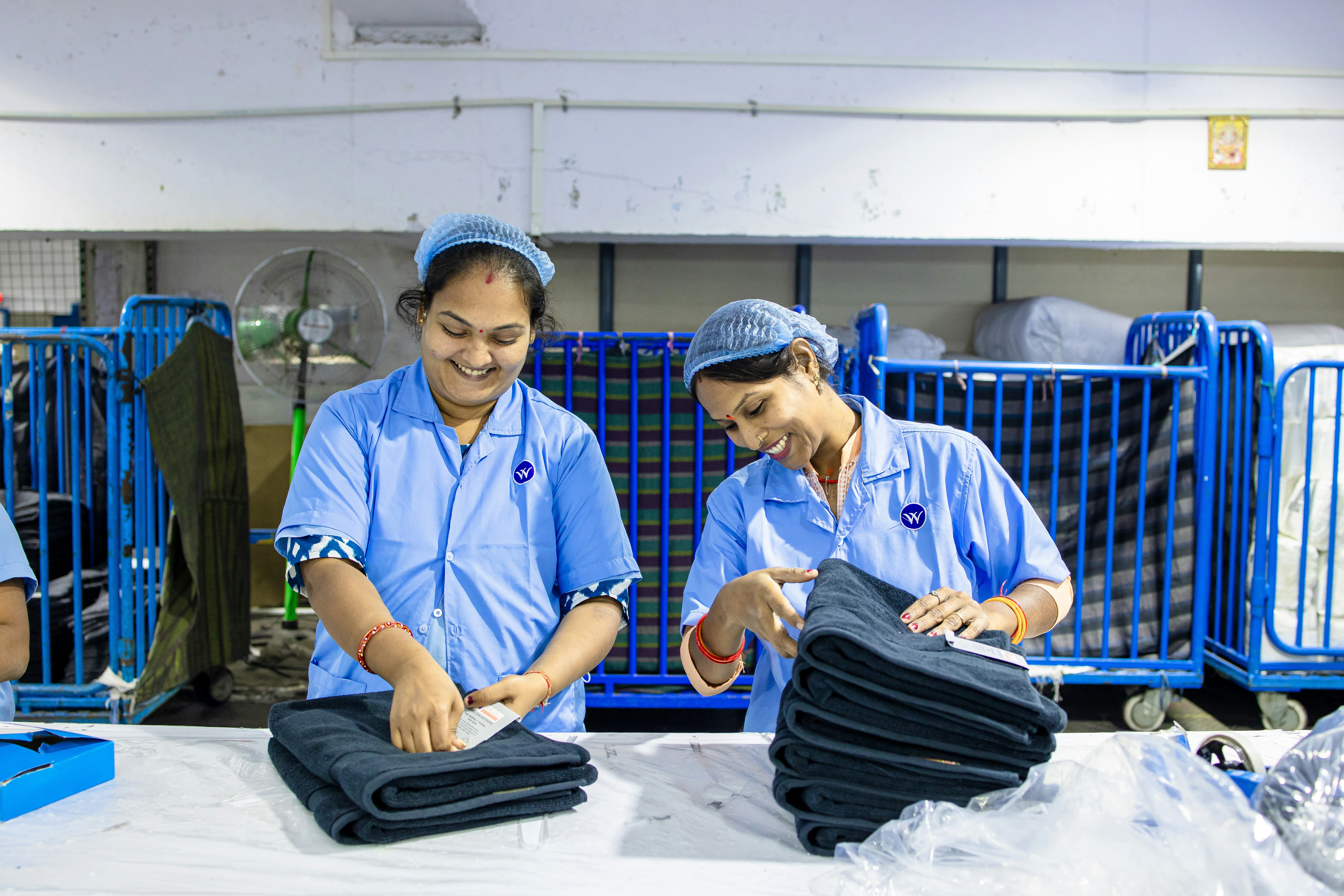 Workers fold jeans in a textile factory.