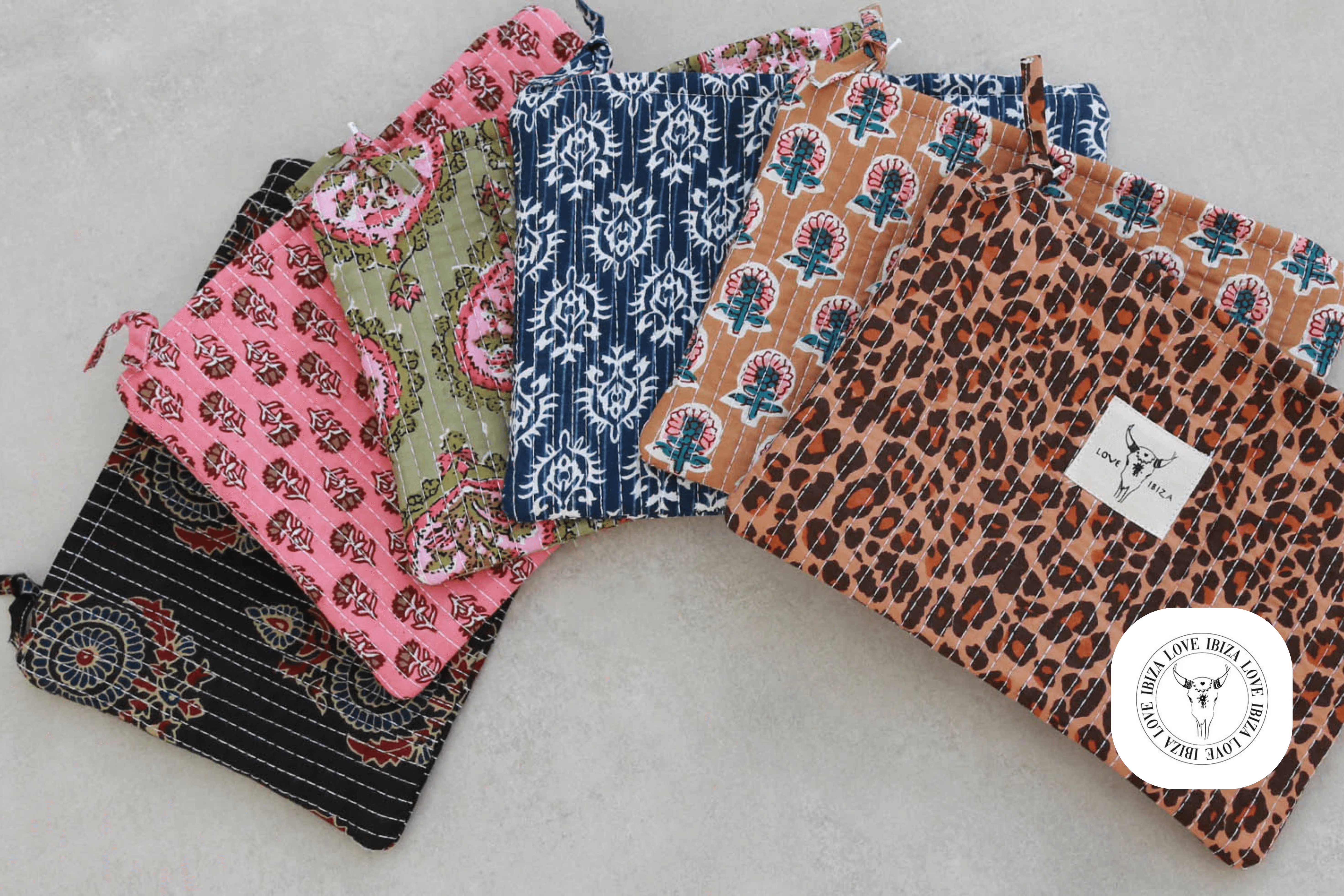 Love Ibiza collection of patterned fabric pouches arranged on a neutral surface
