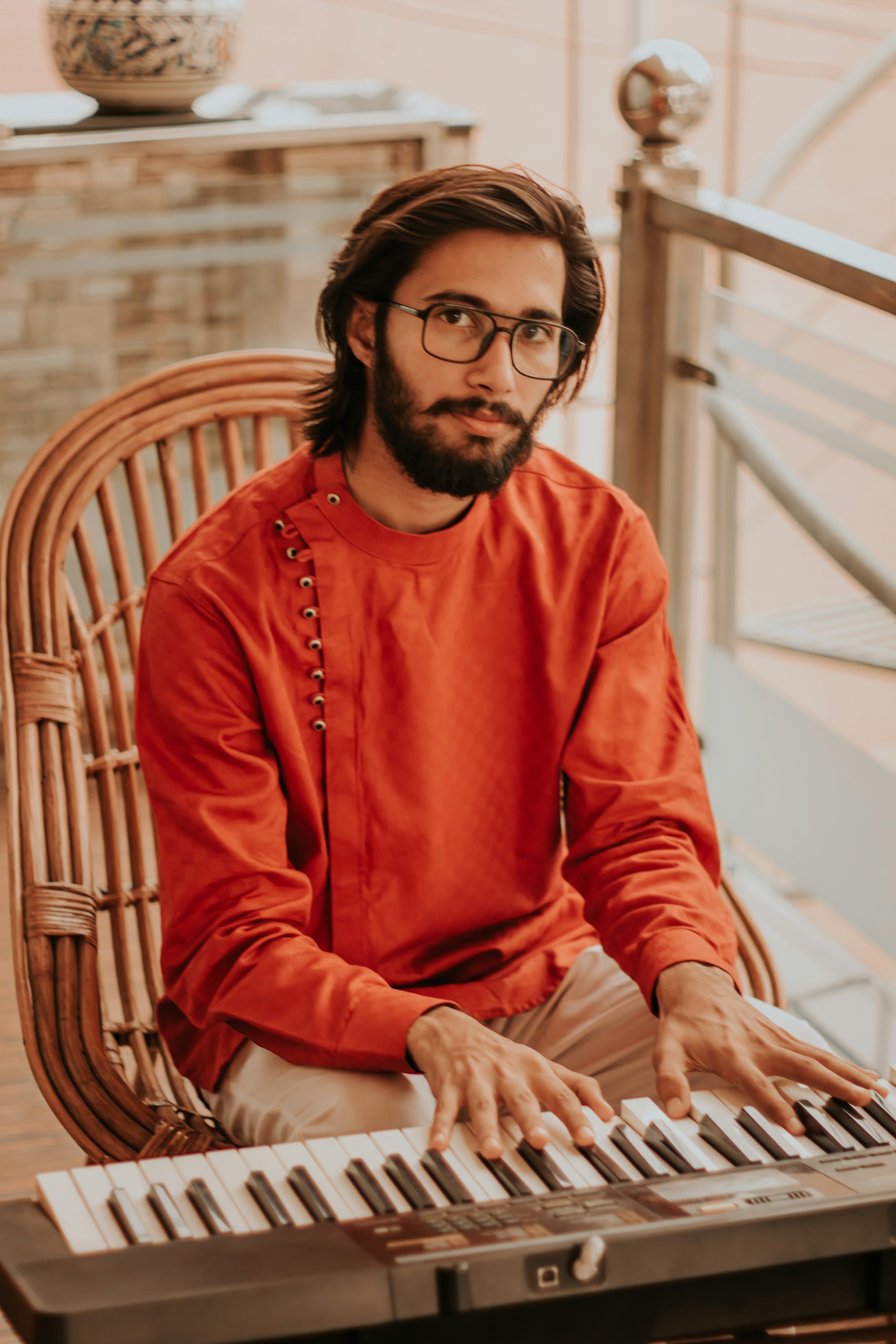 woman in orange long sleeve shirt sitting on brown wooden armchair