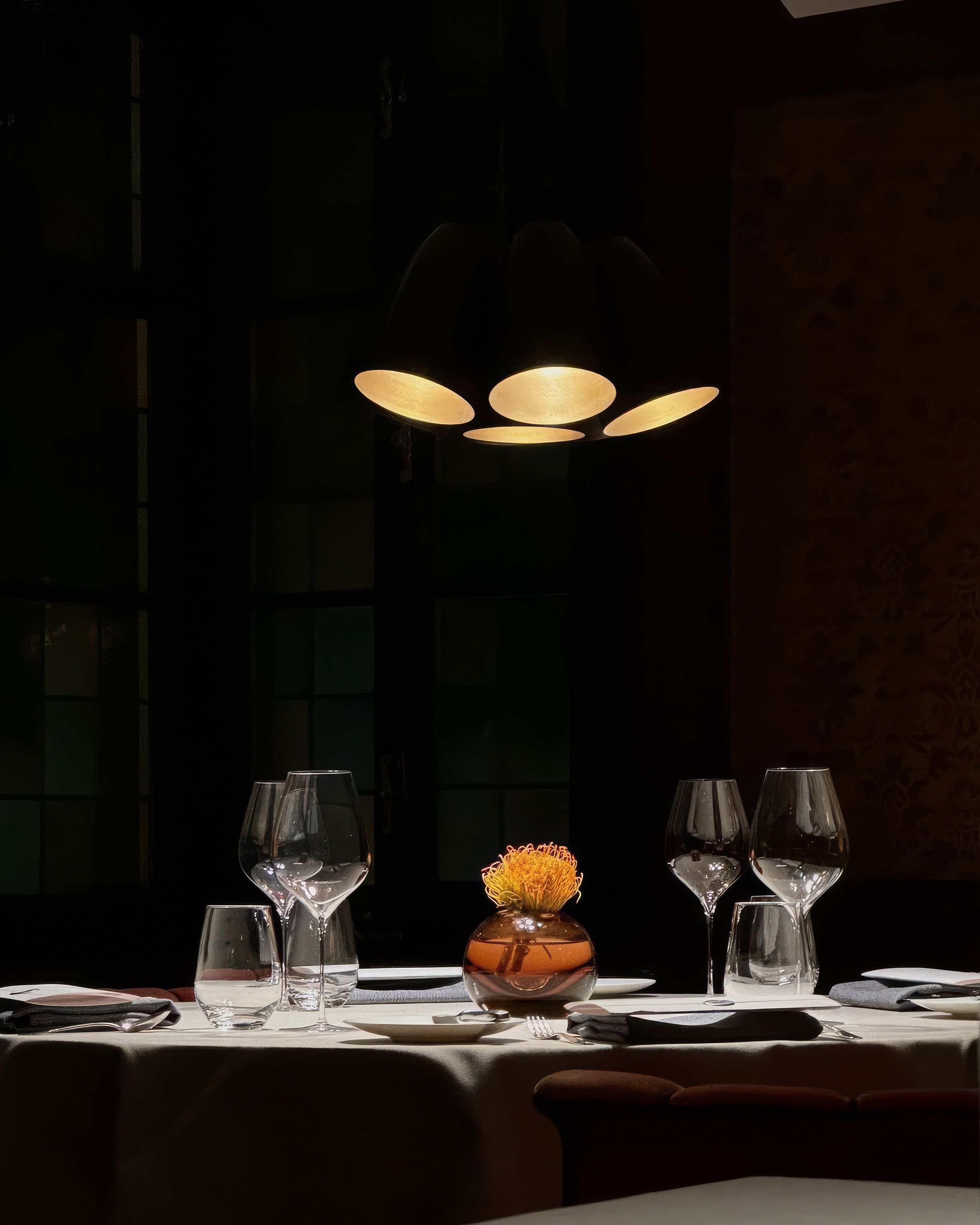 Portrait of a curly-haired man in a rust-and-white striped knit sweater under a clear blue sky—modern fashion look.